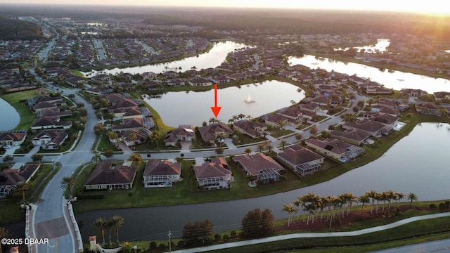 aerial view at dusk featuring a water view