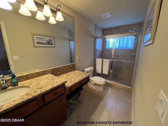 bathroom with vanity, toilet, tile patterned floors, and a shower with door