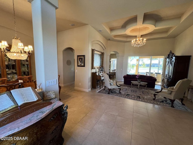 interior space with a towering ceiling, a chandelier, and coffered ceiling