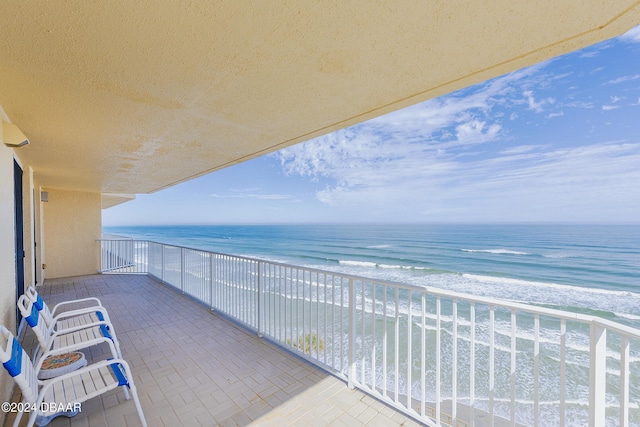 balcony featuring a beach view and a water view