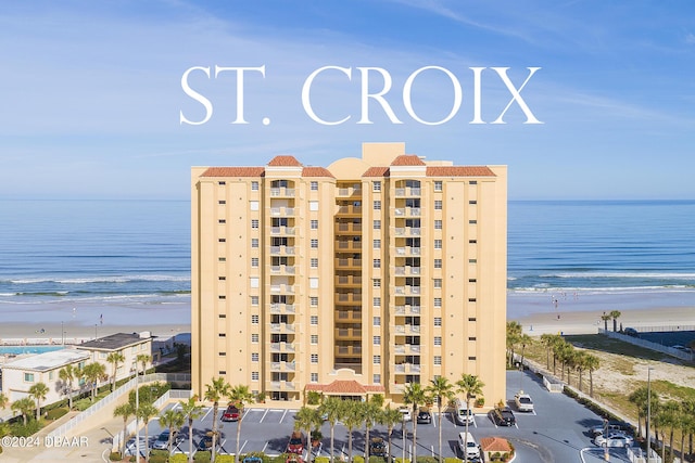 view of building exterior featuring a beach view and a water view