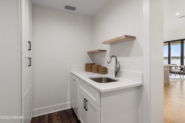 kitchen featuring dark hardwood / wood-style flooring, white cabinetry, and sink