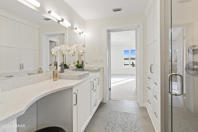 bathroom with tile patterned floors, vanity, and a shower with door