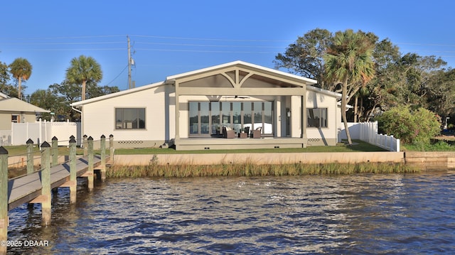 rear view of house featuring ceiling fan and a deck with water view