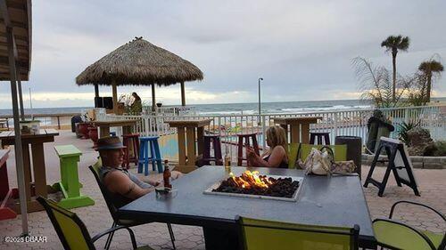 view of jungle gym featuring an outdoor fire pit and a water view