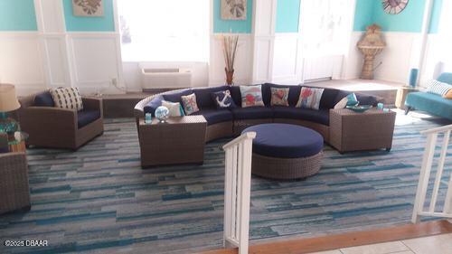 living room featuring radiator, a healthy amount of sunlight, and wainscoting