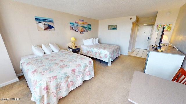 bedroom with light colored carpet and a textured ceiling