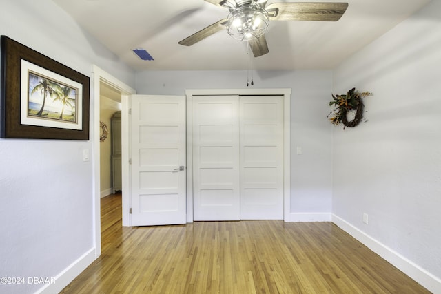 unfurnished bedroom featuring ceiling fan, light hardwood / wood-style floors, and a closet