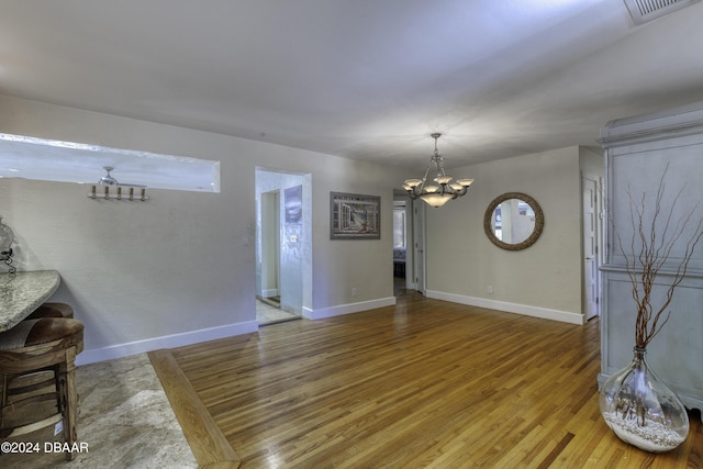 interior space featuring wood-type flooring and an inviting chandelier