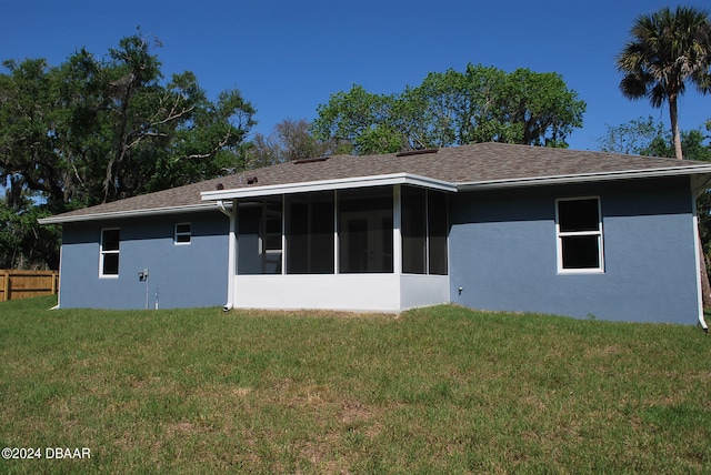 rear view of property featuring a sunroom and a lawn