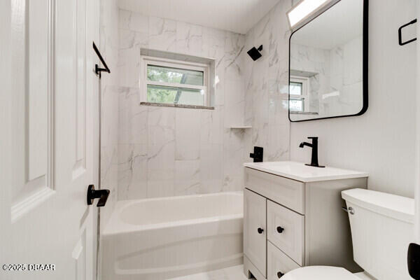 full bathroom with vanity, toilet, and tiled shower / bath combo