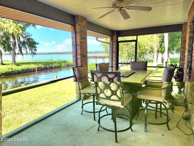 sunroom with a water view and ceiling fan