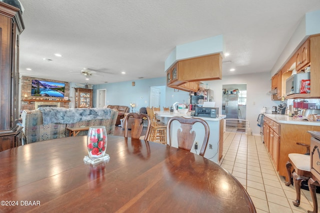 tiled dining room featuring a textured ceiling and ceiling fan