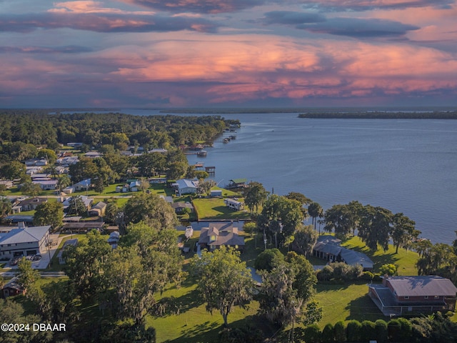 aerial view at dusk featuring a water view