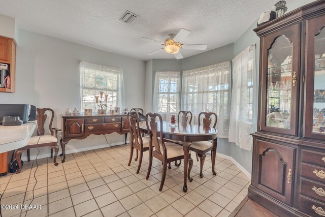 tiled dining room featuring ceiling fan and a textured ceiling