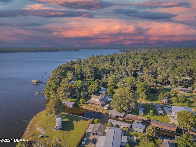 aerial view at dusk featuring a water view