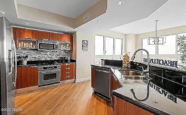 kitchen with dark countertops, dishwasher, oven, and a sink