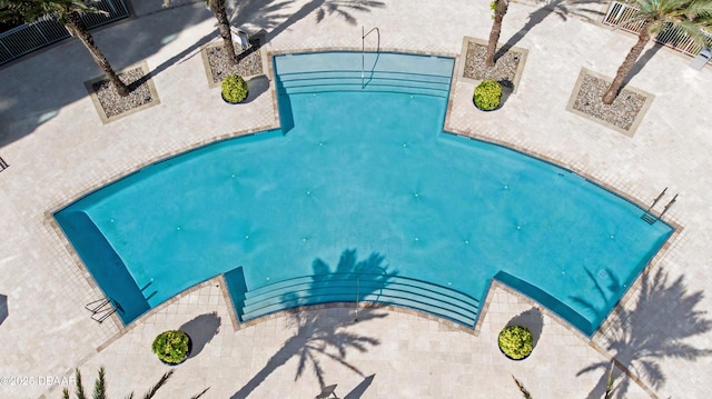 view of swimming pool with a patio and fence