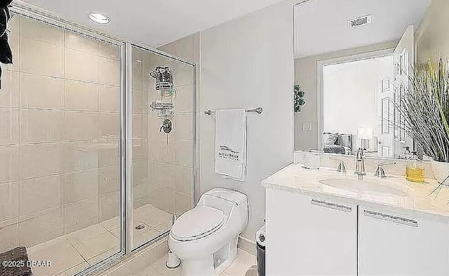 bathroom with vanity, a shower stall, toilet, and visible vents