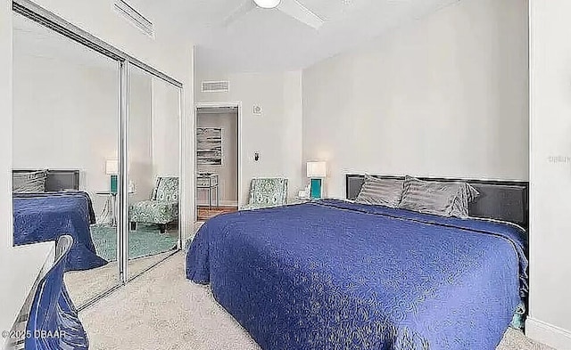 carpeted bedroom featuring a closet and visible vents