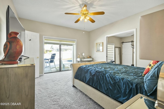 bedroom featuring a barn door, ceiling fan, carpet floors, and access to exterior