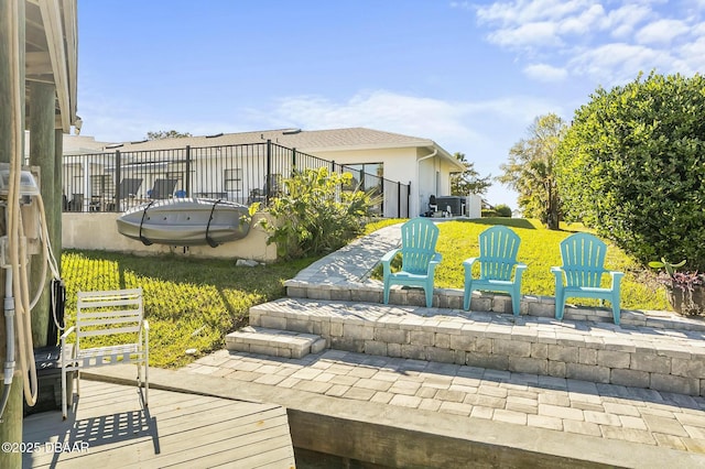 surrounding community with a wooden deck, a patio area, and a lawn