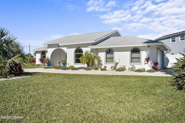 mediterranean / spanish home featuring a front yard and a garage