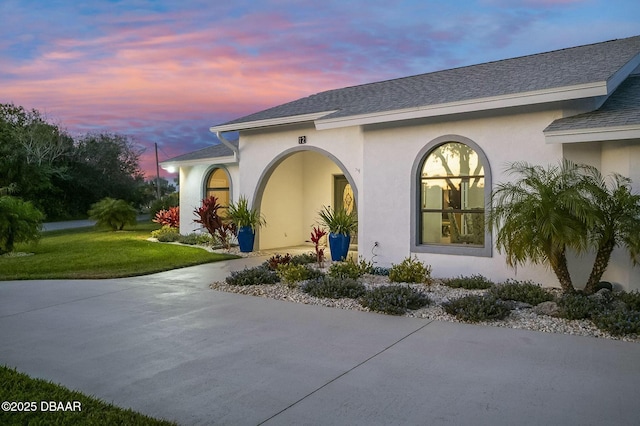 exterior entry at dusk featuring a yard