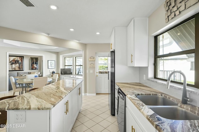 kitchen featuring a center island, light stone countertops, white cabinetry, and sink