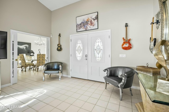 tiled foyer with a high ceiling and a notable chandelier