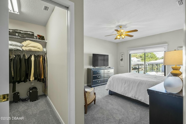 carpeted bedroom featuring access to outside, ceiling fan, and a textured ceiling