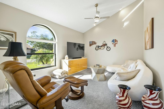 living area featuring ceiling fan, carpet floors, and lofted ceiling