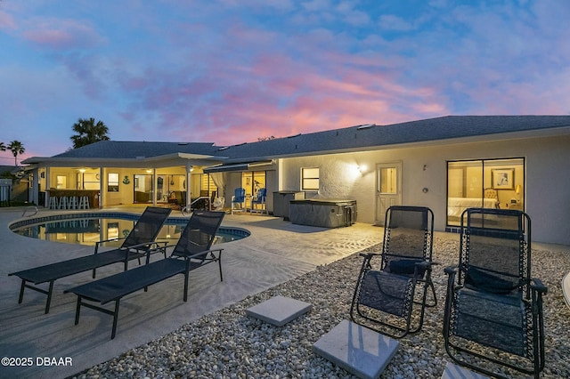 back house at dusk with area for grilling and a patio area