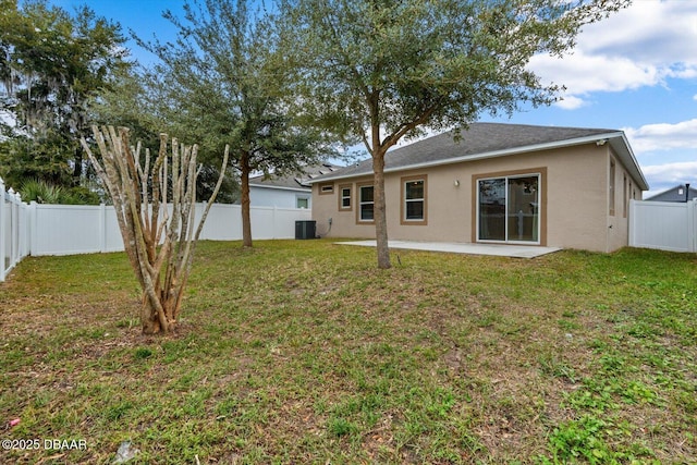 rear view of property with central AC unit, a lawn, and a patio area