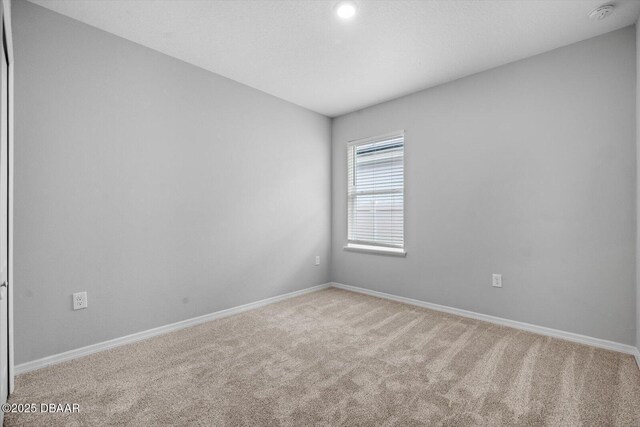 unfurnished room featuring light carpet