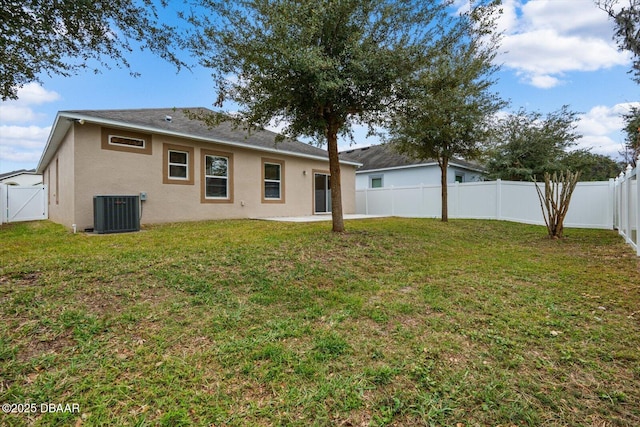 rear view of house featuring a yard and central air condition unit