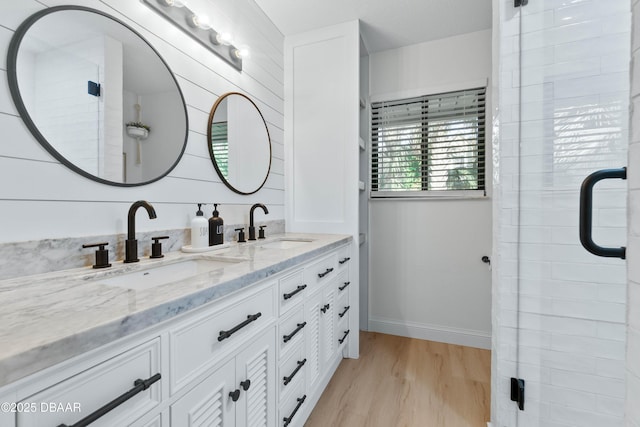 bathroom with wood-type flooring, vanity, and walk in shower