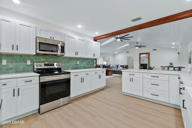 kitchen with white cabinetry, lofted ceiling with beams, light hardwood / wood-style flooring, stainless steel appliances, and decorative backsplash