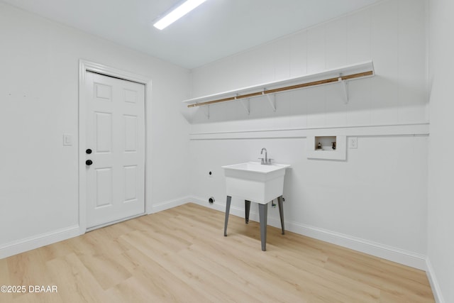 laundry room with electric dryer hookup, washer hookup, and light hardwood / wood-style flooring