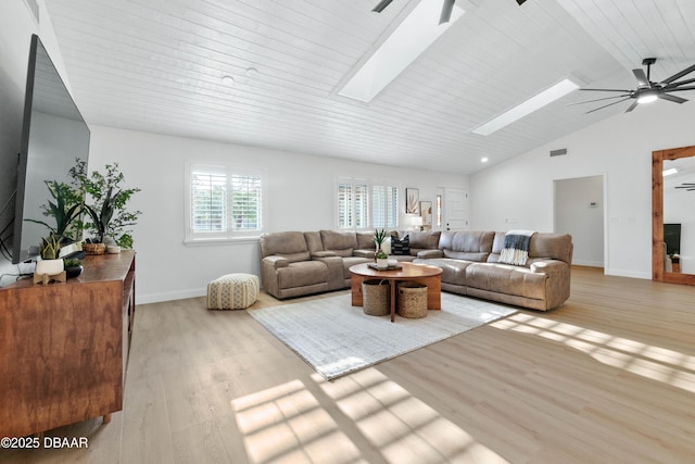 living room featuring lofted ceiling with skylight, light wood-type flooring, wood ceiling, and ceiling fan