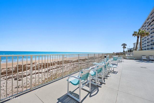 view of patio / terrace featuring a water view and a beach view