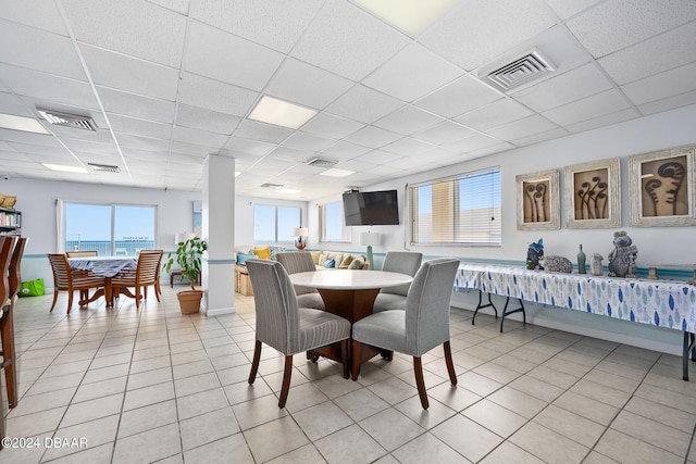 dining room with a drop ceiling and light tile patterned flooring