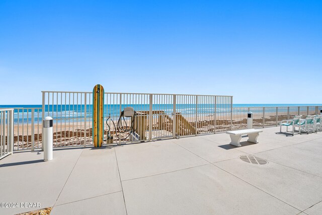 view of patio with a beach view and a water view