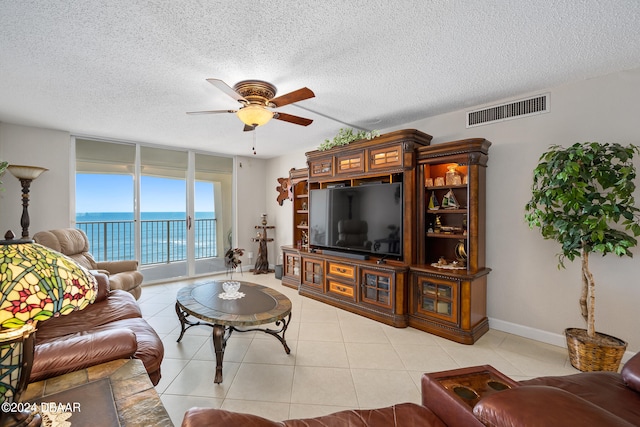 living room with light tile patterned flooring, a textured ceiling, and ceiling fan