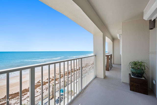 balcony featuring a water view and a beach view