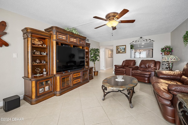 living room featuring a textured ceiling, light tile patterned floors, and ceiling fan with notable chandelier