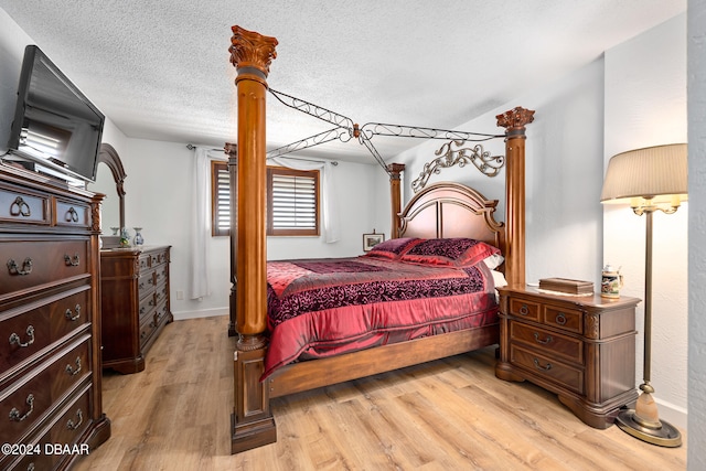 bedroom featuring light hardwood / wood-style floors and a textured ceiling