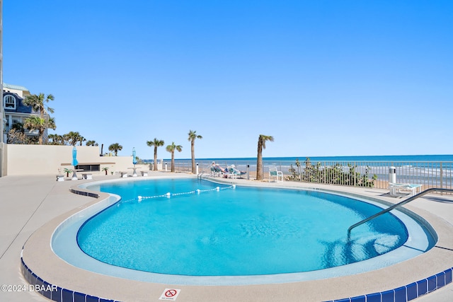 view of swimming pool featuring a patio area and a water view