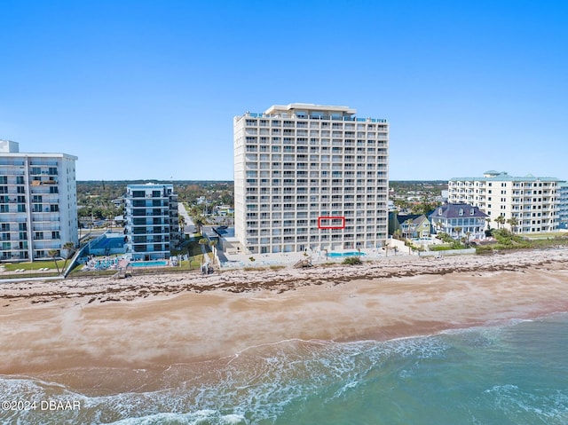 view of building exterior with a view of the beach and a water view