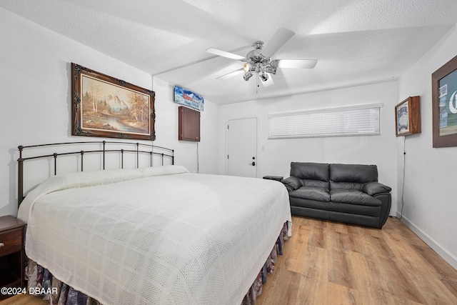 bedroom featuring ceiling fan, a textured ceiling, and light hardwood / wood-style floors